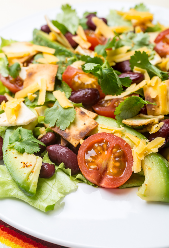 keto taco salad on a bed of lettuce by jasperdaywellness